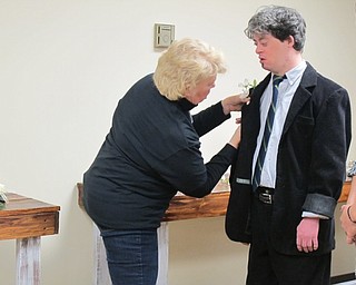 Neighbors | Alexis Bartolomucci.One of the guests got a boutonniere at the Night to Shine Prom at Highway Tabernacle on Feb. 10 to prepare for the dance.