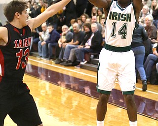 Dakota Hobbs(14) of Ursuline goes up for three as Zach Bezon(13) of Salem tries to block his shot during the 1st quarter as Salem takes on Ursuline in the Division II District Final, Saturday, March 11, 2017 at Boardman High School. Ursuline won 70-33...(Nikos Frazier | The Vindicator)..