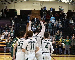 Anthony Howell(1) of Ursuline hoists up their first place trophy after Ursuline beat Salem, 70-33 in the Division II District Final, Saturday, March 11, 2017 at Boardman High School. ..(Nikos Frazier | The Vindicator)..
