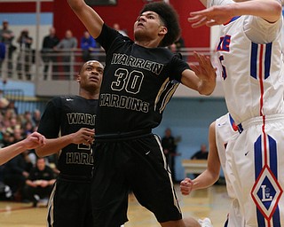 MICHAEL G TAYLOR | THE VINDICATOR- 03-11-17  -Basketball-  1st qtr, Harding's #30 Mike Hughes drives the lane against Lkae's #45 Matt Spotleson. D1 District Final- Warren G. Harding Raiders vs Uniontown Lake Blue Streaks at Alliance High School in Alliance, OH