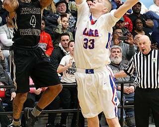 MICHAEL G TAYLOR | THE VINDICATOR- 03-11-17  -Basketball-  4tht qtr., Harding's #4 Lynn Bowden nails a game tying 3 pointer as time expires in regulation over Lake's #33 Mike Spotleson. D1 District Final- Warren G. Harding Raiders vs Uniontown Lake Blue Streaks at Alliance High School in Alliance, OH