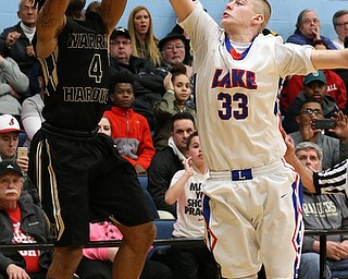 MICHAEL G TAYLOR | THE VINDICATOR- 03-11-17  -Basketball-  4tht qtr., Harding's #4 Lynn Bowden nails a game tying 3 pointer as time expires in regulation over Lake's #33 Mike Spotleson. D1 District Final- Warren G. Harding Raiders vs Uniontown Lake Blue Streaks at Alliance High School in Alliance, OH