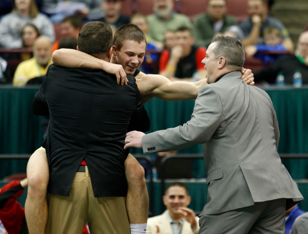 Canfield's David Crawford, center, celebrates with his father and coach Dave Crawford, left, and coach Dean Conley following his overtime win over New Lexington's Dimitri Williams in a 170 pound championship match during the Division II Ohio state wrestling tournament at the Ohio State University Saturday, March 11, 2017. (Photo by Paul Vernon)