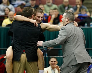 Canfield's David Crawford, center, celebrates with his father and coach Dave Crawford, left, and coach Dean Conley following his overtime win over New Lexington's Dimitri Williams in a 170 pound championship match during the Division II Ohio state wrestling tournament at the Ohio State University Saturday, March 11, 2017. (Photo by Paul Vernon)