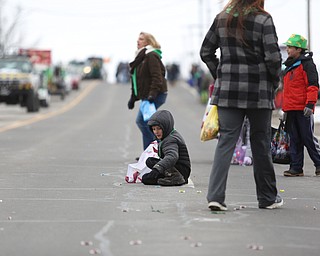 Cooper Brinsko, 9, of Austintown, sits on the ground while collecting candy during the Mahoning Valley St. Patrick's Day Parade on Market Street in Boardman, Sunday, March 12, 2017. ..(Nikos Frazier | The Vindicator)..