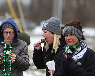 Brooke Shingleton of Boardman(center) tries a smoked potato during the Mahoning Valley St. Patrick's Day Parade on Market Street in Boardman, Sunday, March 12, 2017. ..(Nikos Frazier | The Vindicator)..