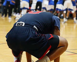 MICHAEL G TAYLOR | THE VINDICATOR- 03-17-17  -Basketball-  JFK's #0 Hyland Burton crestfallen as the Falcons celebrate their victory.  D4 Regional Final, Cleve Luthern East Falcons vs JFK Eagles at Canton Fieldhouse in Canton, OH