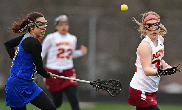 YOUNGSTOWN, OHIO - MARCh 20, 2017: Kirsten Joss #32 of Mooney and Megan Berndt #19 of Poland battle for the loose ball in the air during the first half of their game Monday evening at Mooney High School. DAVID DERMER | THE VINDICATOR