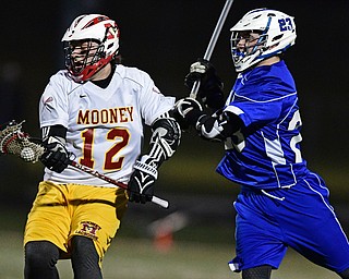 YOUNGSTOWN, OHIO - MARCh 20, 2017: Mark Riccirdi #12 of Mooney runs with the ball while being pressured by Rhys Jones #23 of Poland during the first half of their game Monday night at Mooney High School. DAVID DERMER | THE VINDICATOR