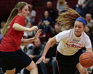 BOARDMAN, OHIO - MARCH 21, 2017: Kristy Eckman, white, drives on Samantha Homa, red, during the first half of the 2017 Al Beach Classic, Tuesday night at Boardman High School. DAVID DERMER | THE VINDICATOR