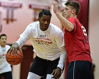 BOARDMAN, OHIO - MARCH 21, 2017: Anthony Howell, white, drives on Chris Muir, red, during the first half of the 2017 Al Beach Classic, Tuesday night at Boardman High School. DAVID DERMER | THE VINDICATOR