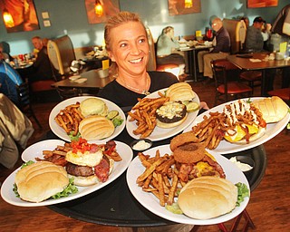 William D. Lewis The Vindicator   Phoenix Fire Grill server Andrea Thompson brings on a platter of burgers for Burger Guyz during their March 29, 2017 visit to the Canfield eatery.