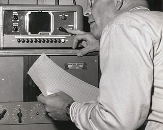 Charles V. Blunt, a Canfield Fair director, tests the intercommunication system between the fair office and principal outlying barn and exhibit area in 1958.