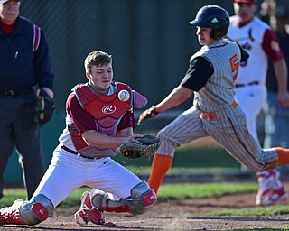 STRUTHERS, OHIO - MARCH 29, 2017: Catcher Jake Fonderlin #6 of Mooney bobbles the ball after a throw from the outfield while base runner Keith Rounds #5 of Howland dives for home to score a run in the third inning of Wednesday nights game at Cene Park. DAVID DERMER | THE VINDICATOR