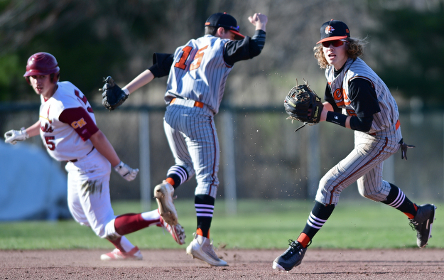 STRUTHERS, OHIO - MARCH 29, 2017: Short stop Dylan Keller #6 of Howland looks to first base after fielding the ball while third basemen Frank Rappach #15 and Ryan Stafanec #15 of Mooney collide behind him in the third inning of Wednesday nights game at Cene Park. DAVID DERMER | THE VINDICATOR