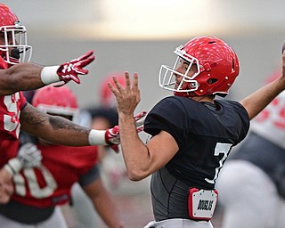 YOUNGSTOWN, OHIO - MARCH 31, 2017: Quarterback Nathan Mays #7, black, throws a pass from the pocket while avoiding pressure from Fazson Chapman #98, red, during practice Friday afternoon at the Watts training facility. DAVID DERMER | THE VINDICATOR