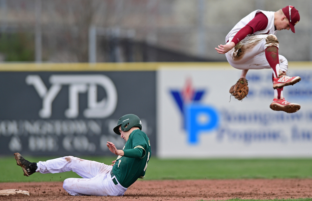 STRUTHERS, OHIO - APRIL 4, 2017:  Base runner Bobby Cavalier #7 of Ursuline steals second base while short stop Bryce Richey #8 of Mooney flies over him after a high throw from the catcher sent him airborne in the third inning of Tuesday nights game at Cene Park. Mooney won 10-6. DAVID DERMER | THE VINDICATOR