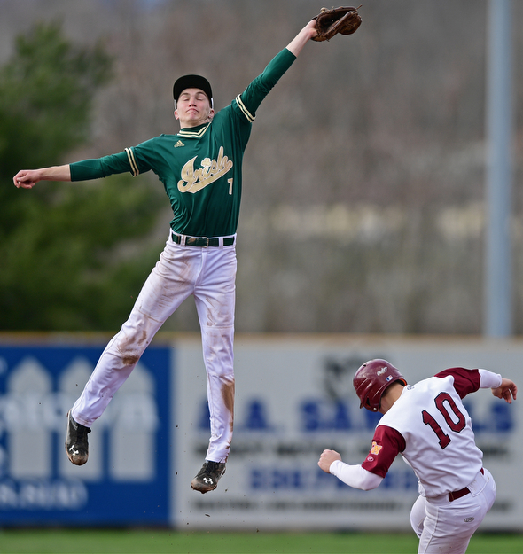 STRUTHERS, OHIO - APRIL 4, 2017: Short stop Bobby Cavalier #7 of Ursuline flies through the air to catch the high throw from the catcher while Dom Pecchia #10 of Mooney steals second base in the third inning of Tuesday nights game at Cene Park. Mooney won 10-6. DAVID DERMER | THE VINDICATOR