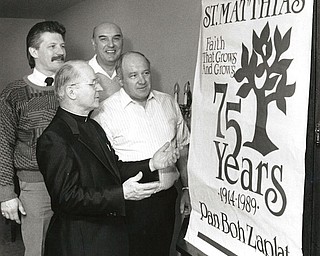 The Rev. Francis Snock, foreground, pastor of St. Matthias Church, discusses a large banner, which was specially designed for the celebration of the church’s 75th jubilee with members of the anniversary committee. In rear, from left, are Len Krispinsky, publicity chairman; Al Pasquale, general chairman; and Edwin Buday. co-chairman.