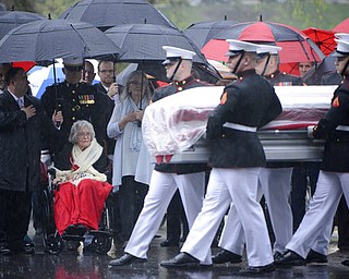 In this U.S. Army photo by Rachel Larue/Arlington National Cemetery, Annie Glenn, seated, widow of John Glenn, watches as members of the U.S. Marine Corps from Marine Barracks Washington carry the casket of her husband during his graveside service at Arlington National Cemetery in Arlington, Va. Thursday, April 6, 2017. Glenn, who died Dec. 8 at age 95, was laid to rest in a private burial attended by relatives and invited guests. His family scheduled the service for what would have been John and Annie Glenn's 74th wedding anniversary. (U.S. Army photo by Rachel Larue/Arlington National Cemetery via AP)