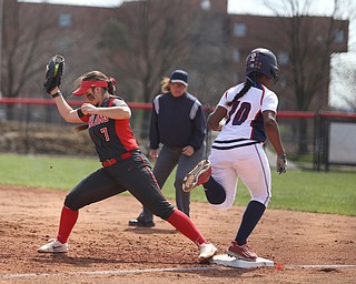UIC junior infielder Tiana Mack-Miller(10) runs to first as Youngstown State junior first baseman Kelly Thompson-Cappadocio(7) opens up her mitt for the pass during the 3rd inning as the UIC Flames take on the Youngstown State Penguins, Sunday, April 9, 2017 at the YSU Softball Field. The Flames won 2-1...(Nikos Frazier | The Vindicator)..
