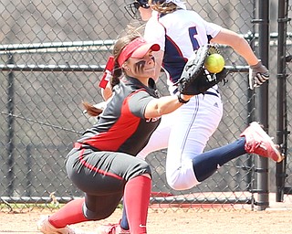 Youngstown State junior first baseman Kelly Thompson-Cappadocio(7) leans down for the pass as UIC freshman infielder Kayla Wedl(6) tags onto first during the 5th inning as the UIC Flames take on the Youngstown State Penguins, Sunday, April 9, 2017 at the YSU Softball Field. The Flames won 2-1...(Nikos Frazier | The Vindicator)..