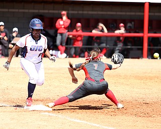 Youngstown State junior first baseman Kelly Thompson-Cappadocio(7) leans down for the pass as UIC junior infielder Tiana Mack-Miller(10) tags onto first during the 7th inning as the UIC Flames take on the Youngstown State Penguins, Sunday, April 9, 2017 at the YSU Softball Field. The Flames won 2-1...(Nikos Frazier | The Vindicator)..