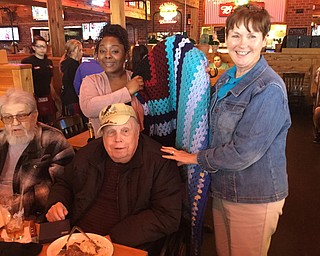 SPECIAL TO THE VINDICATOR
AMVETS Post 44 recently hosted veterans who are residents at Maplecrest Nursing Home, Struthers, and Sunrise Assisted Living, Poland, at Texas Roadhouse in Boardman. Jan Brown, right, commander of the post and AMVETS National third vice commander, presented an afghan to a veteran during the dinner, which was accepted on his behalf by a residential aide from Sunrise.