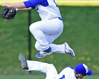HUBBARD, OHIO - APRIL 13, 2017: Hubbard's Lukas Mosora, top, hurdles over Jamie Thomson, bottom, after Thomson dove to catch the ball in the third inning of Thursday evenings game at Hubbard High School. DAVID DERMER | THE VINDICATOR