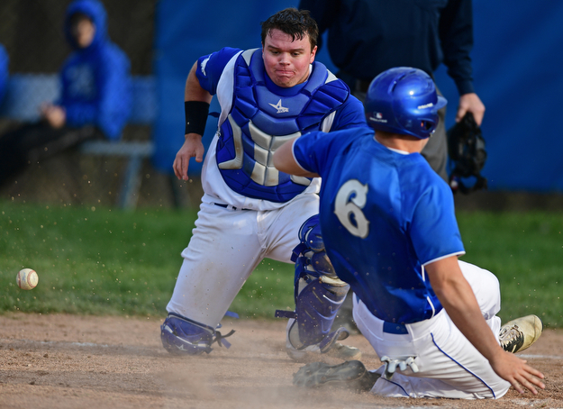 HUBBARD, OHIO - APRIL 13, 2017: Hubbard catcher Tim Herberger, left, bobbles the ball as Poland's Cole Kosco steals home to score a run in the sixth inning of Thursday evenings game at Hubbard High School. DAVID DERMER | THE VINDICATOR