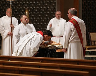 Fr. Michael Swierz kisses the body of Christ during the Good Friday Stations of the Cross at St. Patrick Church, Friday, April 14, 2017 in Hubbard. ..(Nikos Frazier | The Vindicator)..