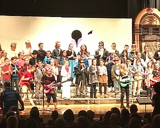 Neighbors | Alexis Bartolomucci.Girls came to the front of the stage to play guitar for one of the songs during the Dobbins fourth-grade concert on March 14 at Poland Seminary High School.