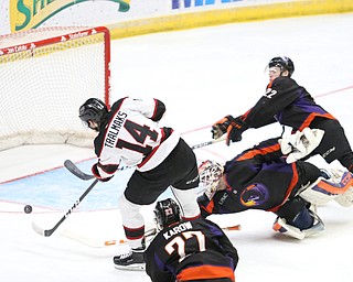 Chicago Steel left wing Eduards Tralmaks (14) shoots for a goal as Youngstown Phantoms defenseman Brandon Estes (22) and Youngstown Phantoms goalie Ivan Kulbakov (31) trip over each other during the 3rd period as the Chicago Steel takes on the Youngstown Phantoms in Game 4 of the USHL Eastern Conference Semifinals, Saturday, April 22, 2017 at The Covelli Centre in Youngstown. The Phantoms won 3-2...Youngstown Phantoms defenseman Michael Karow (27)..(Nikos Frazier | The Vindicator)..