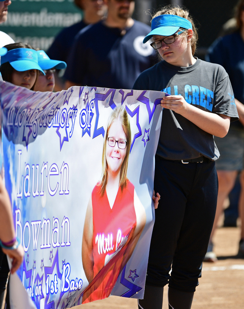 YOUNGSTOWN, OHIO - APRIL 23, 2017: Katie Merdich of Youngstown looks at the banner that was unveiled of her former teammate Lauren Bowman, during the Mill Creek Junior Baseball opening ceremonies, Sunday afternoon at the Mill Creek baseball field complex. DAVID DERMER | THE VINDICATOR