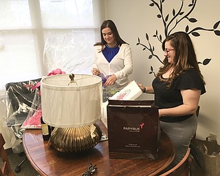 SPECIAL TO THE VINDICATOR
Emily Martin, AmeriCorps volunteer, left, and Jessica Driscoll, Beatitude House development associate, prepare auction items for the organization’s annual wine taste and auction.