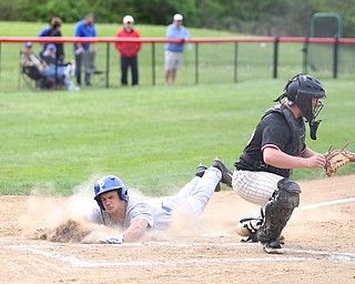 Poland's Braeden O'Shaughnessy(4) slides into home as Canfield catcher Angelo Petracci(25) waits for the ball during the 1st inning as Poland High School takes on Canfield High School, Tuesday, March 25, 2017 at Phil Bova Field. Poland won 9-1...(Nikos Frazier | The Vindicator)..