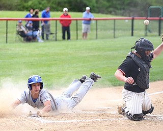 Poland's Braeden O'Shaughnessy(4) slides into home as Canfield catcher Angelo Petracci(25) misses the ball during the 1st inning as Poland High School takes on Canfield High School, Tuesday, March 25, 2017 at Phil Bova Field. Poland won 9-1...(Nikos Frazier | The Vindicator)..