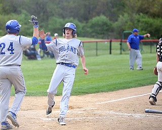 Poland's Reed McCreery high fives teammate Dan Klase(24) after they both scored a run as Canfield catcher Angelo Petracci(25) waits for the ball during the 1st inning as Poland High School takes on Canfield High School, Tuesday, March 25, 2017 at Phil Bova Field. Poland won 9-1...(Nikos Frazier | The Vindicator)..