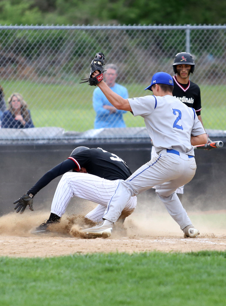 Canfield's Jimmy Fitzgerald(32) slides into home on a steal as Poland's Spencer Woolley(2) tries to tag him out during the 4th inning as Poland High School takes on Canfield High School, Tuesday, March 25, 2017 at Phil Bova Field. Poland won 9-1...(Nikos Frazier | The Vindicator)..
