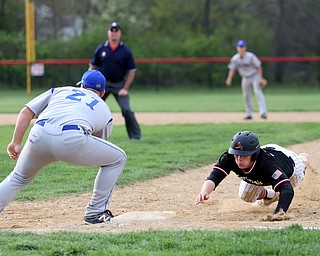 Canfield's Mark Wittmann(21) slides back into first as Poland first baseman Padraig O'Shaughnessy(21) leans down for the pass during the 5th inning as Poland High School takes on Canfield High School, Tuesday, March 25, 2017 at Phil Bova Field. Poland won 9-1...(Nikos Frazier | The Vindicator)..
