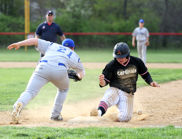 Canfield's Mark Wittmann(21) slides back into first as Poland first baseman Padraig O'Shaughnessy(21) scrambles to grab his missed pass during the 5th inning as Poland High School takes on Canfield High School, Tuesday, March 25, 2017 at Phil Bova Field. Poland won 9-1...(Nikos Frazier | The Vindicator)..