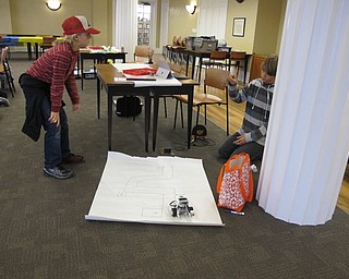 Neighbors | Alexis Bartolomucci.Children programmed their Lego Mindstorms Robots to follow a drawn out track at the Poland library event on March 29.