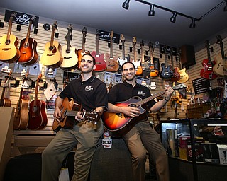 Michael Biviano(left) and Philip Biviano pose for a photo with acoustic guitars at Motter's Music, Friday, April 14, 2017 in Canfield. ..(Nikos Frazier | The Vindicator)..
