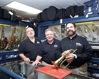 (from left) Tim Cleal, Dave Colella and Dennis Biviano pose for a photo in the repair shop at Motter's Music, Friday, April 14, 2017 in Canfield. ..(Nikos Frazier | The Vindicator)..