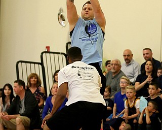 YPD Officer Anthony Congemi(blue) goes up for three during the Battle of the Blue charity basketball event benefiting the Mahoning County Children's Services, Friday, April 28, 2017 at the Arlington Heights Recreation Center in Youngstown. ..(Nikos Frazier | The Vindicator)..
