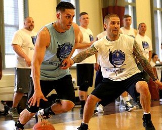YPD Officer Chris Weibel(blue) goes up to the basket against YFD firefighter Christopher Vass(white) during the Battle of the Blue charity basketball event benefiting the Mahoning County Children's Services, Friday, April 28, 2017 at the Arlington Heights Recreation Center in Youngstown. ..(Nikos Frazier | The Vindicator)..