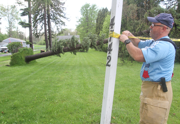 william d Lewis the vindicator  Boardman firefighter Rob Aeiza secures caution tape at the scene of a downed tree on South Ave. A fast moving storm packing strong winds and heavy rain Sunday April 30, 2017 left downed trees and power lines and  many residents without power.