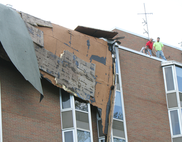 William D. Lewis The vindicator   Workers survey damage to roof of PArk Vista building on Fifth Ave in Youngstown 5-1-17. a late afternoon storm ripped part of the roof from the building.