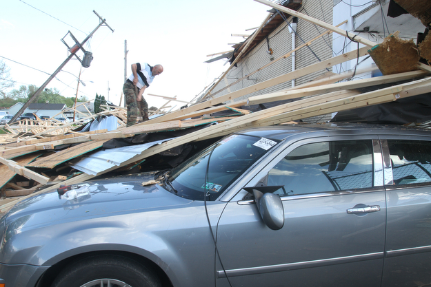 William D. Lewis The vindicator  Clean up continues at Six rothers Auto Sales on Oak St in Youngsotwn. A late afternoon storm ripped the roof from the building.