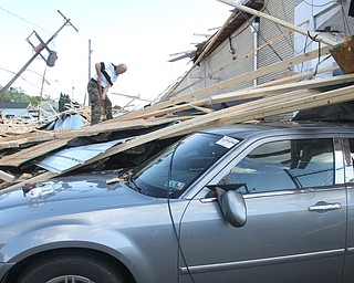 William D. Lewis The vindicator  Clean up continues at Six rothers Auto Sales on Oak St in Youngsotwn. A late afternoon storm ripped the roof from the building.